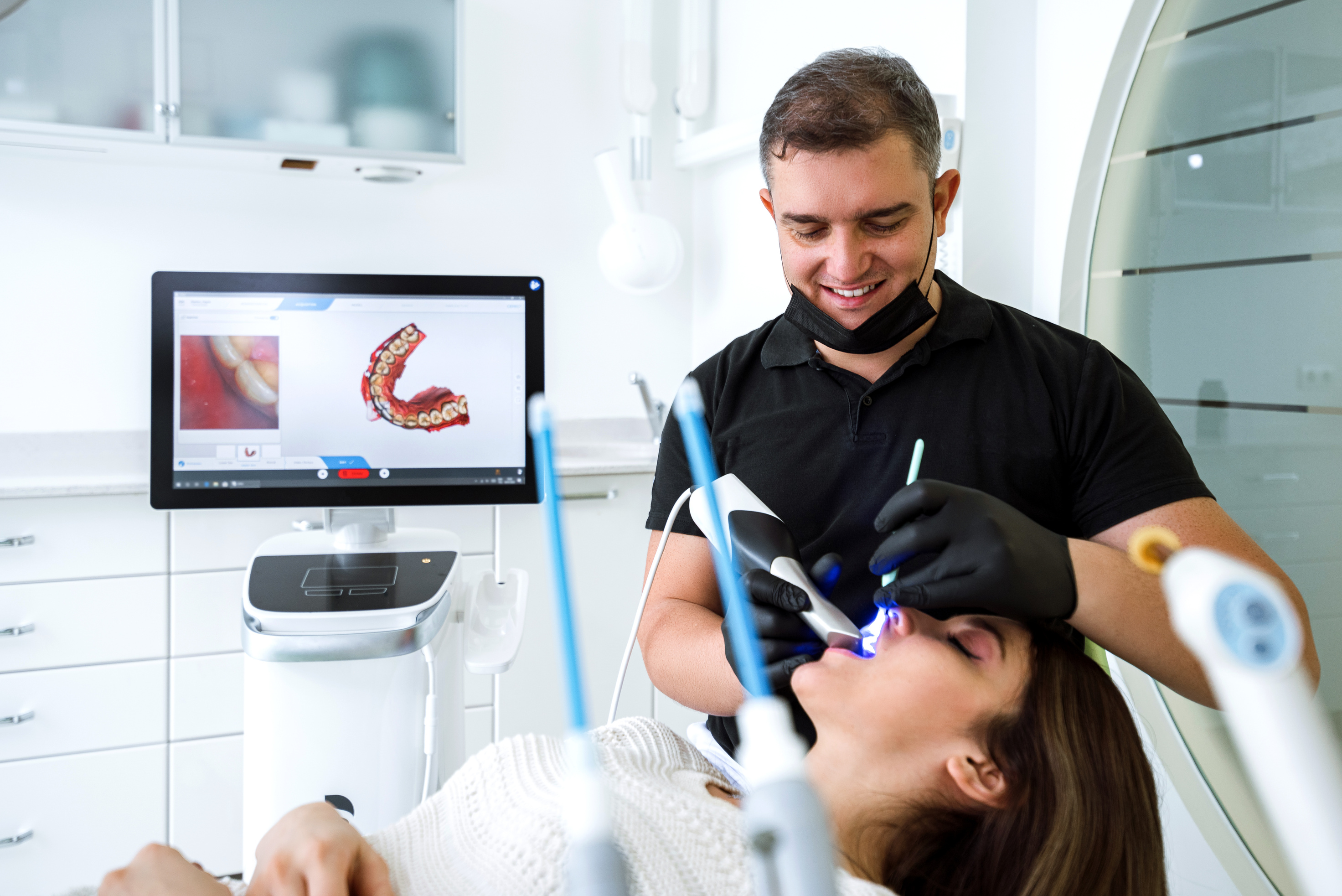 Dentist scanning patient's teeth with a CEREC scanner